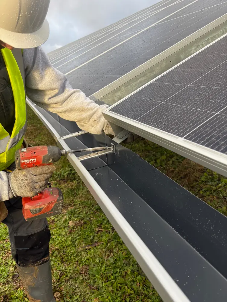 Technicien Alu G fixant une gouttière aluminium en continu sous panneaux photovoltaïques sur le parc solaire de Chamboeuf Côte-d’Or